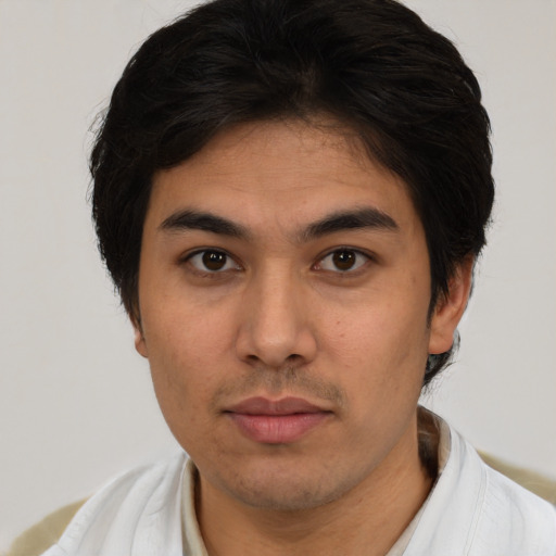 Joyful latino young-adult male with short  brown hair and brown eyes