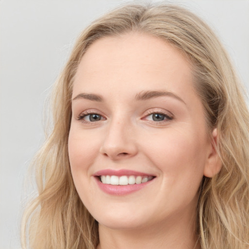 Joyful white young-adult female with long  brown hair and blue eyes