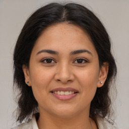 Joyful latino young-adult female with medium  brown hair and brown eyes