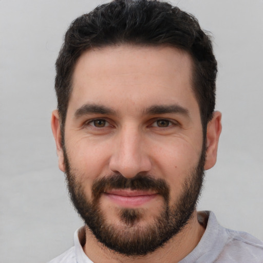 Joyful white young-adult male with short  black hair and brown eyes