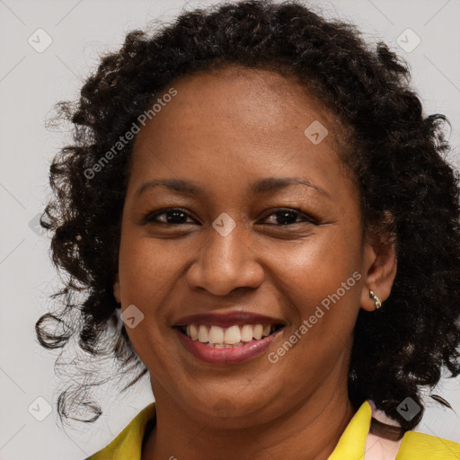 Joyful black young-adult female with long  brown hair and brown eyes