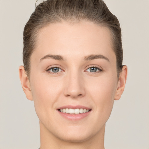 Joyful white young-adult female with short  brown hair and grey eyes