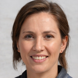 Joyful white adult female with medium  brown hair and grey eyes