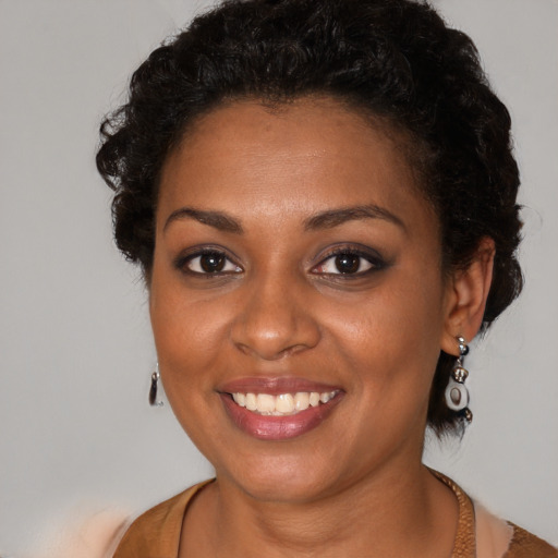 Joyful black young-adult female with medium  brown hair and brown eyes