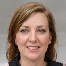 Joyful white adult female with medium  brown hair and grey eyes