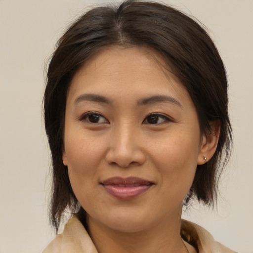 Joyful asian young-adult female with medium  brown hair and brown eyes