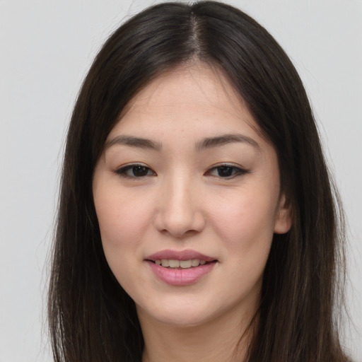 Joyful asian young-adult female with long  brown hair and brown eyes