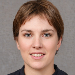 Joyful white young-adult female with medium  brown hair and grey eyes