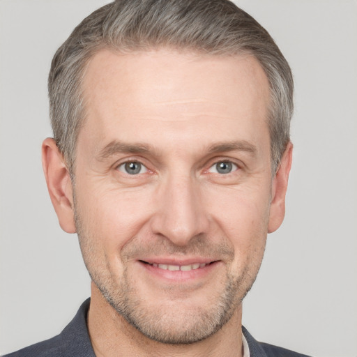 Joyful white adult male with short  brown hair and grey eyes