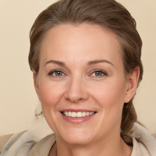 Joyful white adult female with medium  brown hair and grey eyes