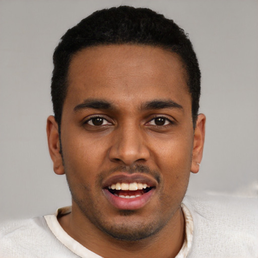 Joyful black young-adult male with short  black hair and brown eyes
