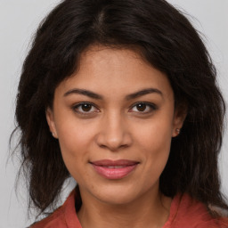 Joyful latino young-adult female with long  brown hair and brown eyes