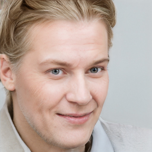 Joyful white adult male with short  brown hair and blue eyes