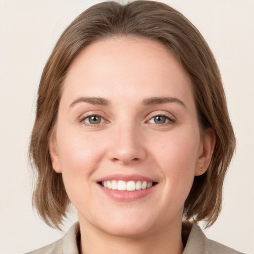 Joyful white young-adult female with medium  brown hair and green eyes