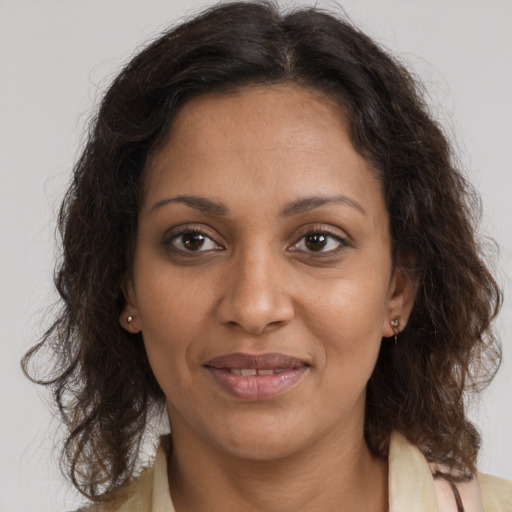 Joyful black adult female with medium  brown hair and brown eyes