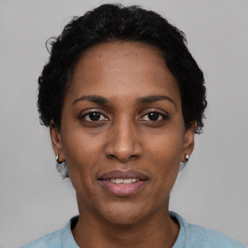 Joyful black adult female with short  black hair and brown eyes