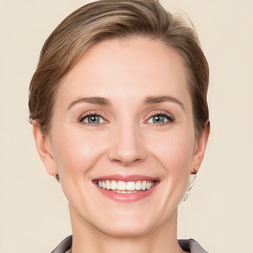 Joyful white young-adult female with medium  brown hair and grey eyes