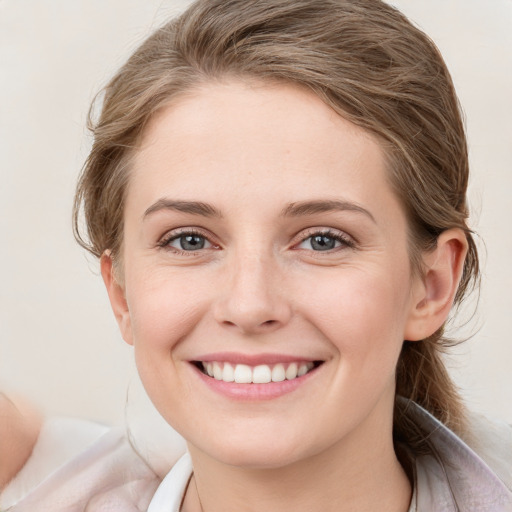 Joyful white young-adult female with medium  brown hair and blue eyes