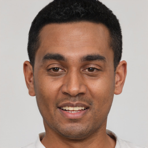 Joyful black young-adult male with short  black hair and brown eyes