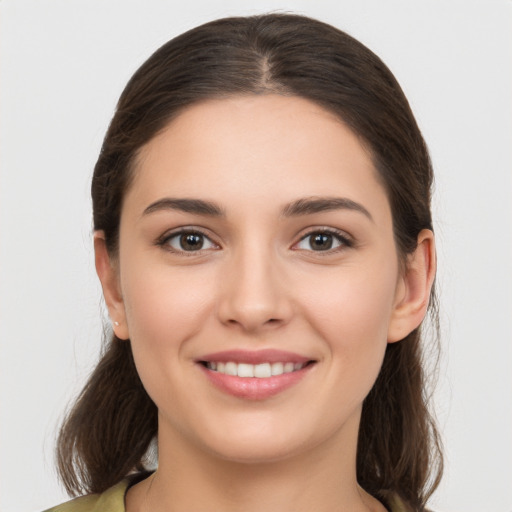 Joyful white young-adult female with long  brown hair and brown eyes