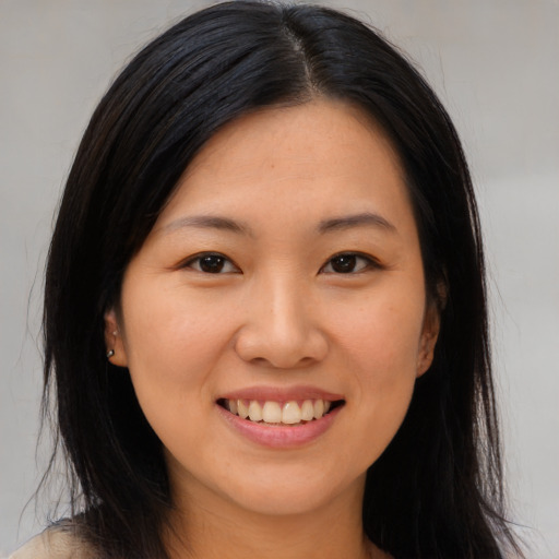 Joyful asian young-adult female with long  brown hair and brown eyes