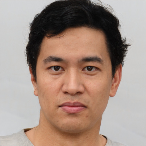 Joyful asian young-adult male with short  brown hair and brown eyes