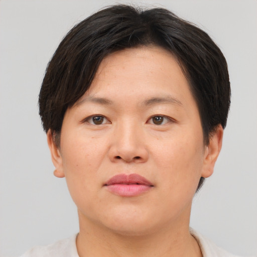 Joyful asian adult female with short  brown hair and brown eyes