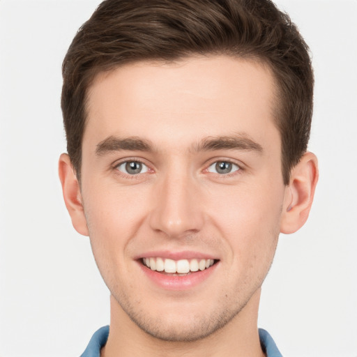 Joyful white young-adult male with short  brown hair and grey eyes