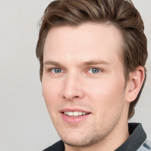 Joyful white young-adult male with short  brown hair and grey eyes