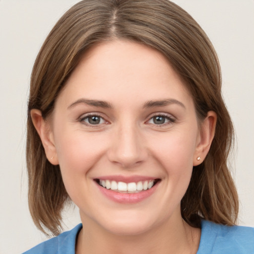 Joyful white young-adult female with medium  brown hair and grey eyes