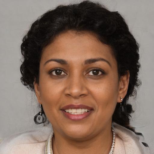 Joyful black adult female with medium  brown hair and brown eyes