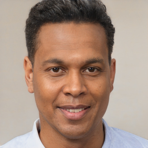 Joyful latino adult male with short  brown hair and brown eyes