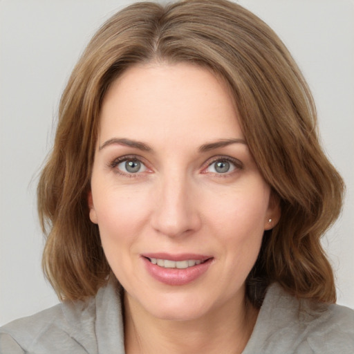 Joyful white young-adult female with medium  brown hair and green eyes