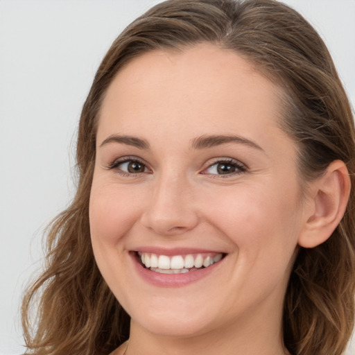 Joyful white young-adult female with long  brown hair and grey eyes