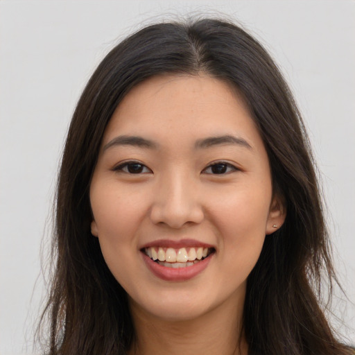 Joyful white young-adult female with long  brown hair and brown eyes