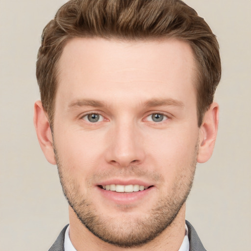 Joyful white young-adult male with short  brown hair and grey eyes