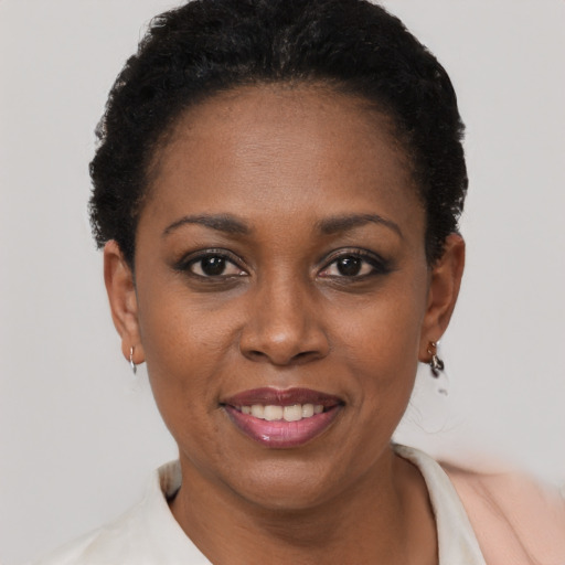 Joyful black young-adult female with short  black hair and brown eyes