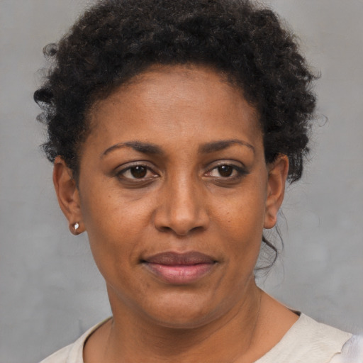 Joyful black adult female with short  brown hair and brown eyes