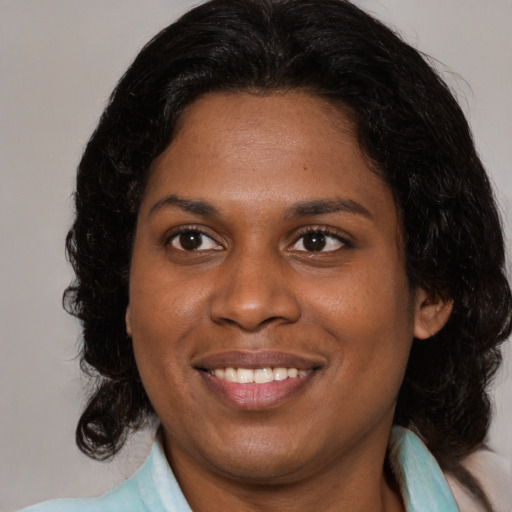 Joyful black young-adult female with medium  brown hair and brown eyes