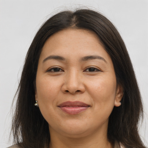 Joyful latino adult female with long  brown hair and brown eyes