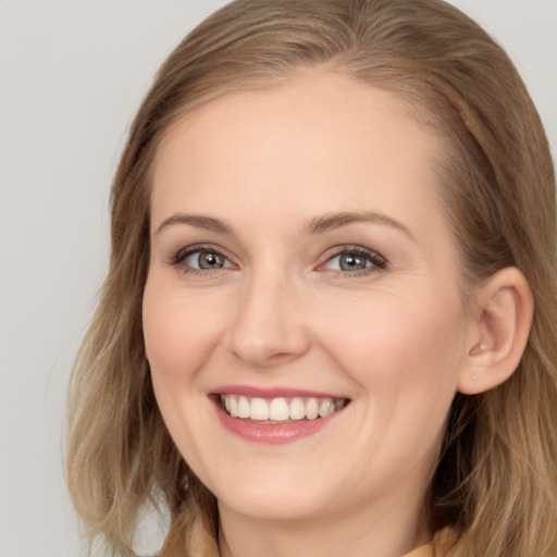 Joyful white young-adult female with long  brown hair and blue eyes