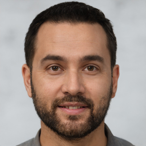 Joyful white young-adult male with short  black hair and brown eyes