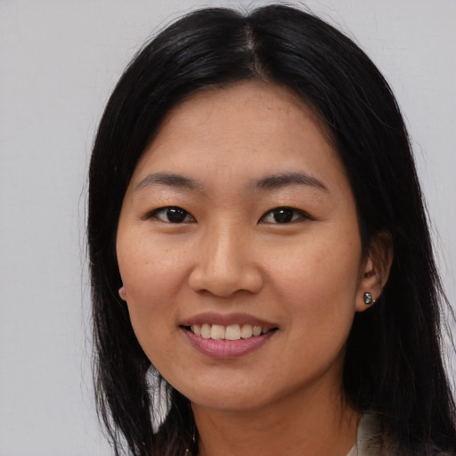 Joyful asian young-adult female with long  black hair and brown eyes
