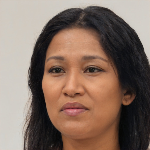 Joyful latino adult female with long  black hair and brown eyes
