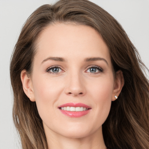 Joyful white young-adult female with long  brown hair and grey eyes