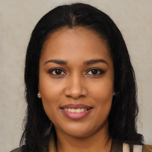 Joyful black young-adult female with long  brown hair and brown eyes