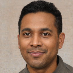 Joyful latino young-adult male with short  black hair and brown eyes