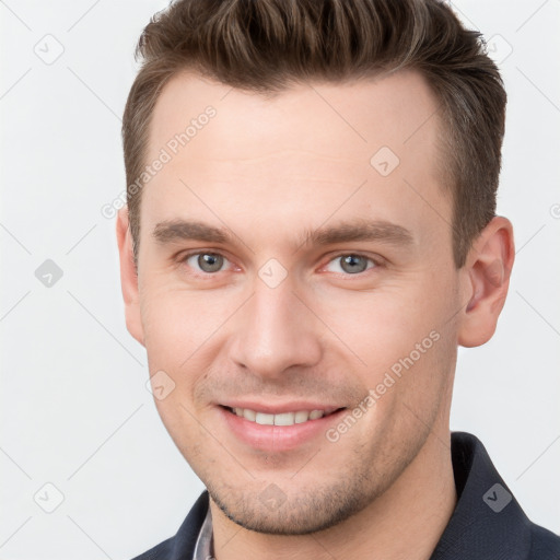 Joyful white young-adult male with short  brown hair and grey eyes