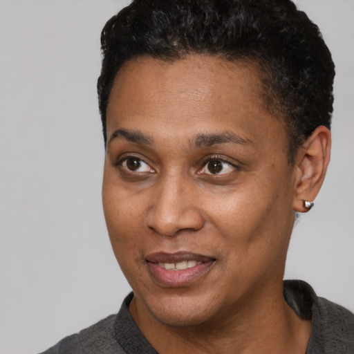 Joyful black young-adult female with short  black hair and brown eyes