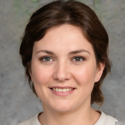 Joyful white young-adult female with medium  brown hair and grey eyes